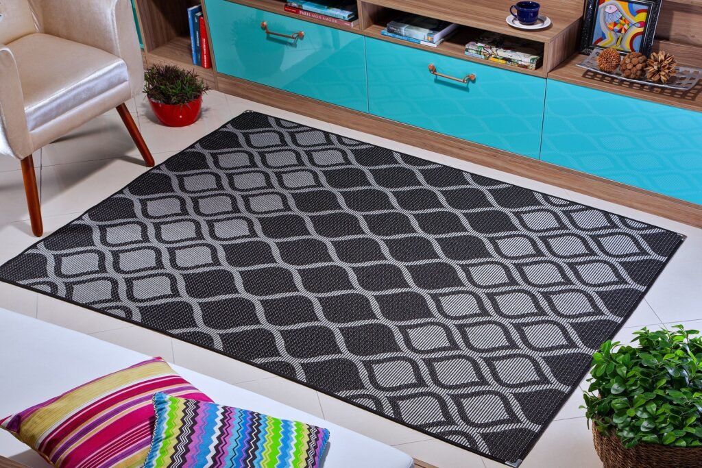 Uma sala de estar com bebê brincando no tapete, protetores de quina nos móveis, e uma grade de proteção ao fundo.
